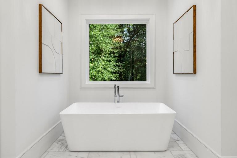 5211 Powers Ferry Road Northwest Sandy Springs, GA 30327 - Photo 54 of 106 a white bath tub sitting in a bathroom next to a window