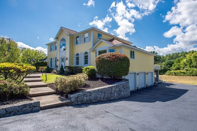 a view of a house with a yard and potted plants