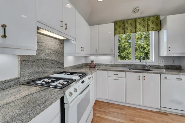 a kitchen with granite countertop cabinets stainless steel appliances and a window