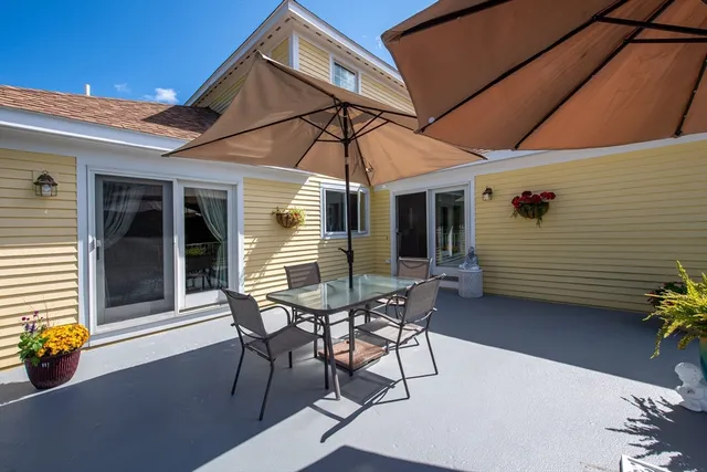a patio with table and chairs and potted plants
