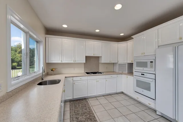 a kitchen with a sink window and cabinets