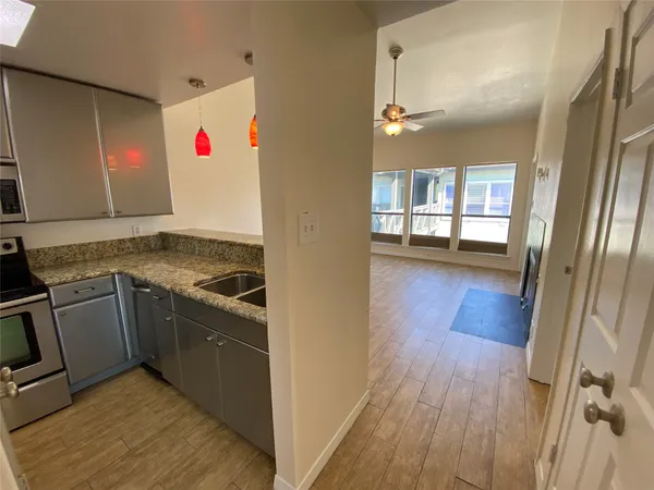 a kitchen with granite countertop a stove and wooden floor