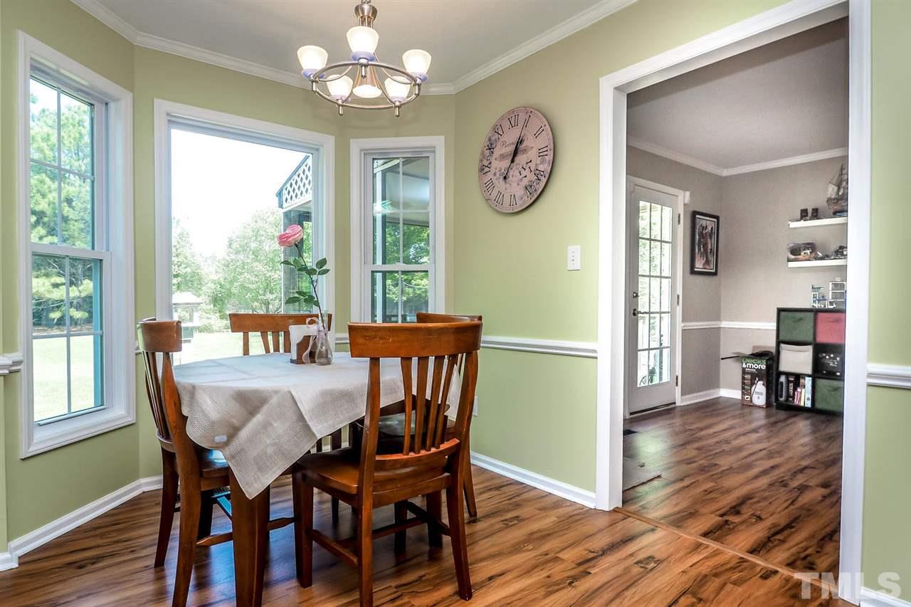 1020 Pagan Road Raleigh, NC 27603 - Photo 7 of 24 a view of a dining room with furniture a chandelier and wooden floor