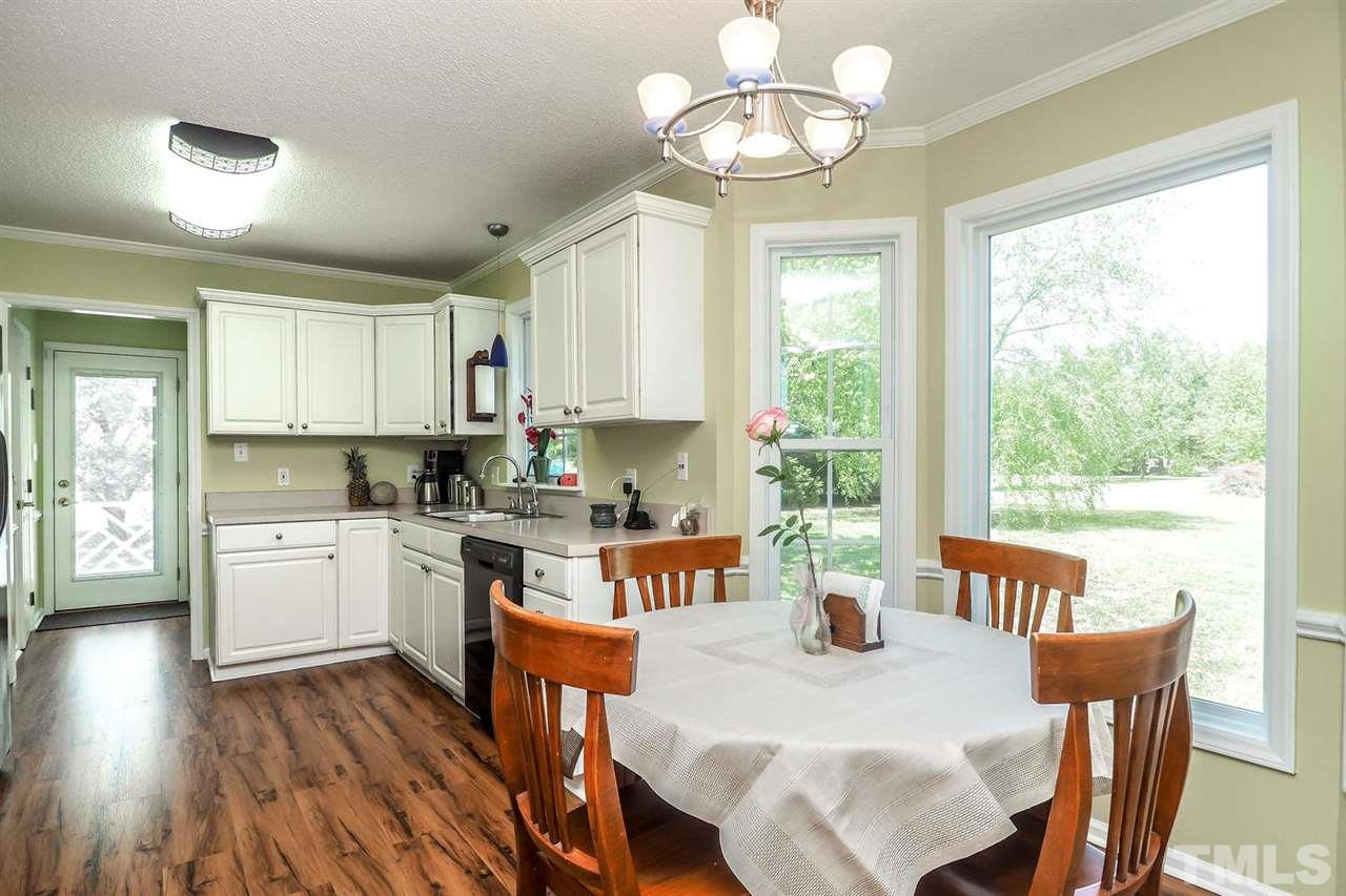 1020 Pagan Road Raleigh, NC 27603 - Photo 9 of 24 a view of a dining room with furniture a chandelier and wooden floor