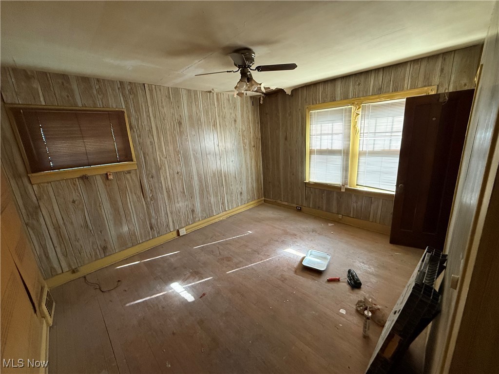 1058 Pembrook Road Cleveland Heights, OH 44121 - Photo 34 of 39 Empty room with wood walls, ceiling fan, and wood finished floors