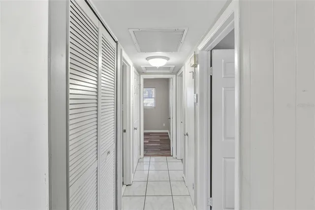 a view of a hallway with wooden floor and a bathroom