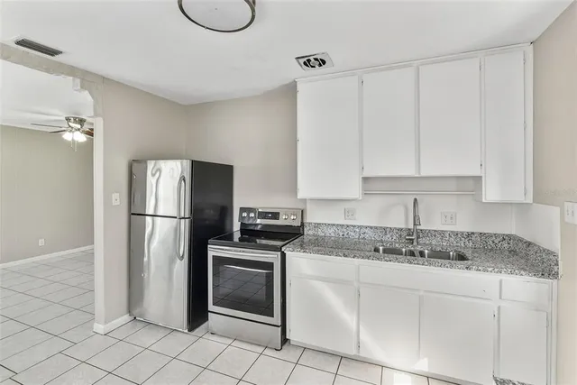 a kitchen with a refrigerator sink and cabinets