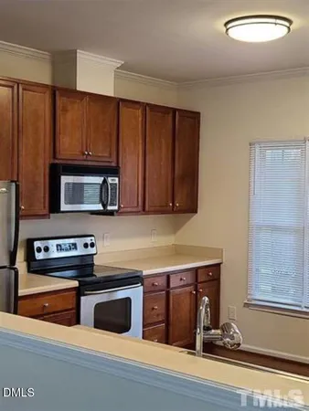 a view of a kitchen with a fridge and wooden floor