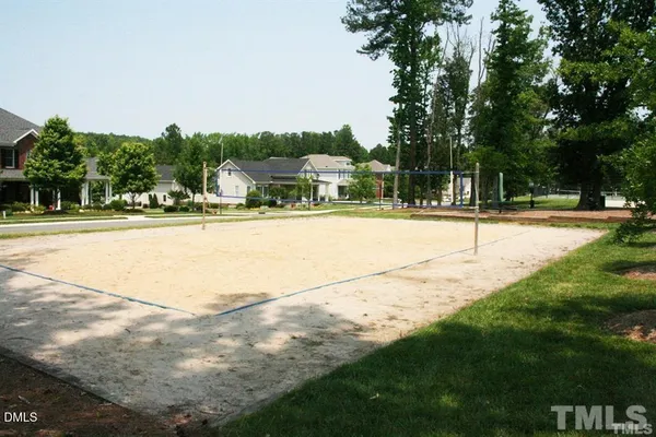 a view of a house with a yard and basketball court
