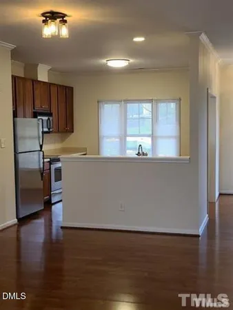 a living room with hard wood floors and a kitchen view