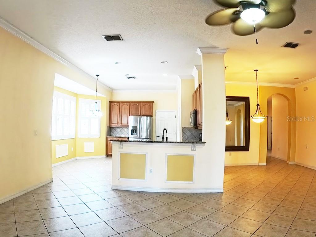 100 Flame Vine Way Groveland, FL 34736 - Photo 12 of 38 a view of a kitchen with kitchen island stainless steel appliances refrigerator stove microwave and cabinets