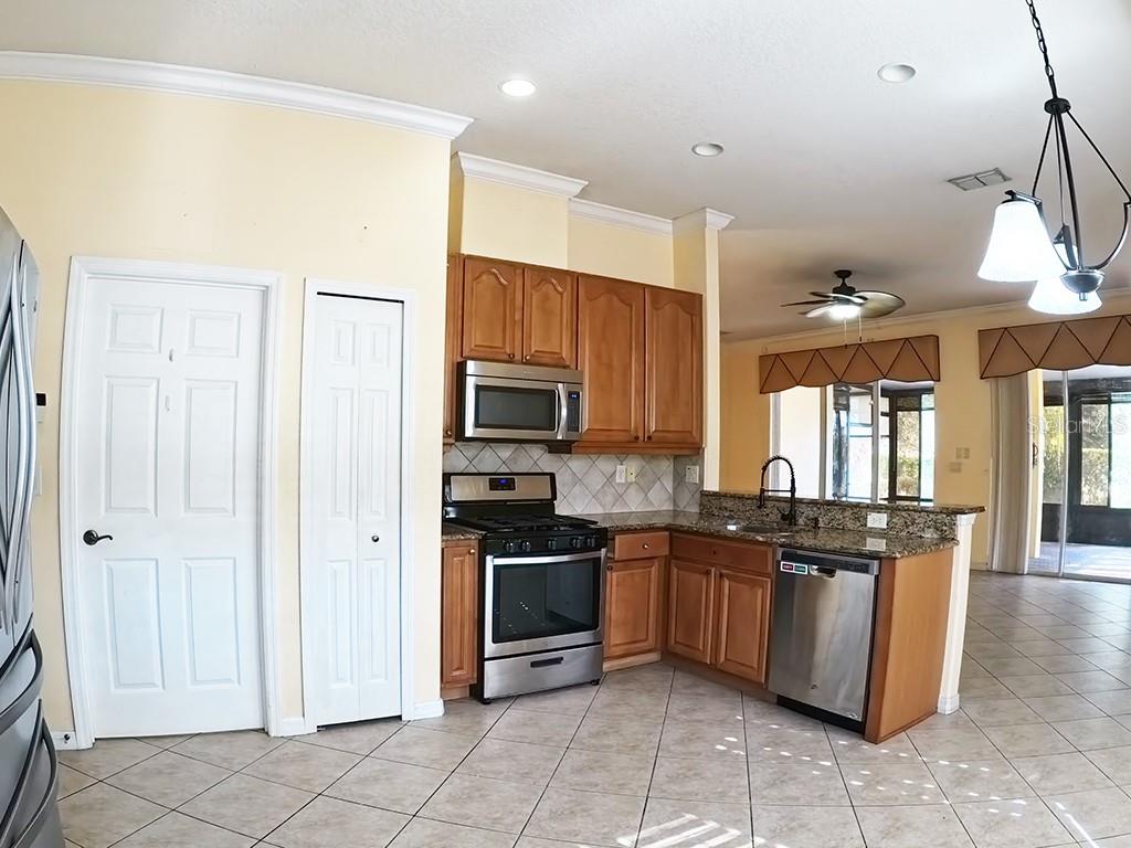 100 Flame Vine Way Groveland, FL 34736 - Photo 15 of 38 a kitchen with stainless steel appliances granite countertop a stove a sink and a refrigerator