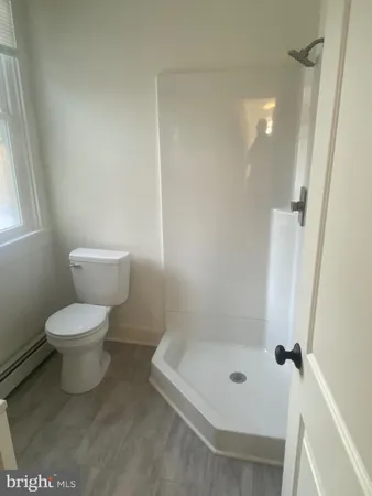 a bathroom with a toilet and a shower