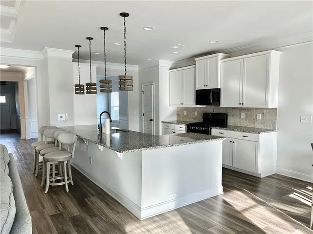 a kitchen with stainless steel appliances a stove a sink a microwave a refrigerator and cabinets