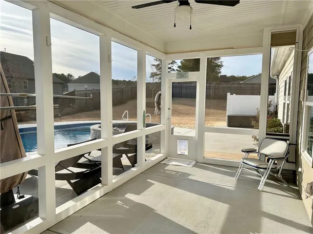 a swimming pool with outdoor seating and yard in the back
