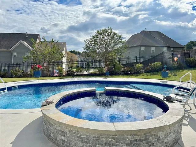 a view of a house with swimming pool and sitting area