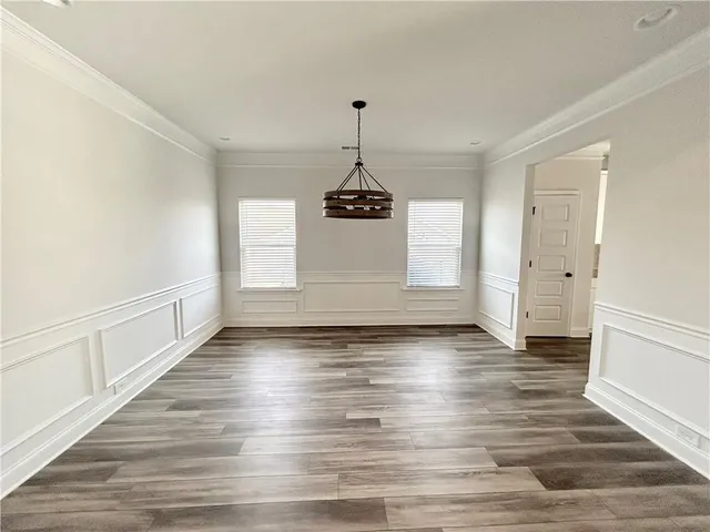 a view of a room with wooden floors and chandelier
