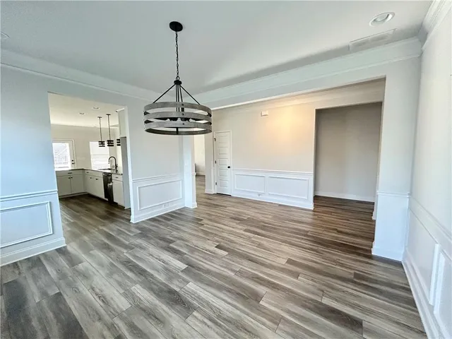a view of a room with wooden floor kitchen and a sink