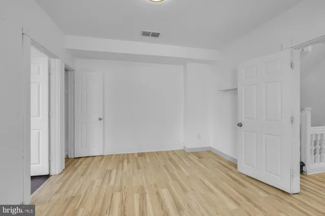 a view of a room with wooden floor and white doors