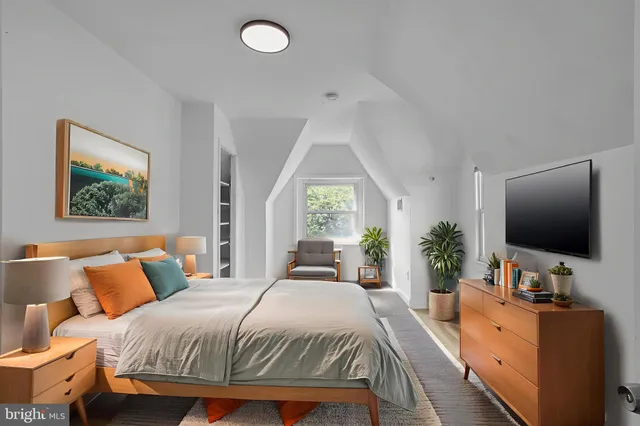 a bedroom with a large bed and a flat screen tv