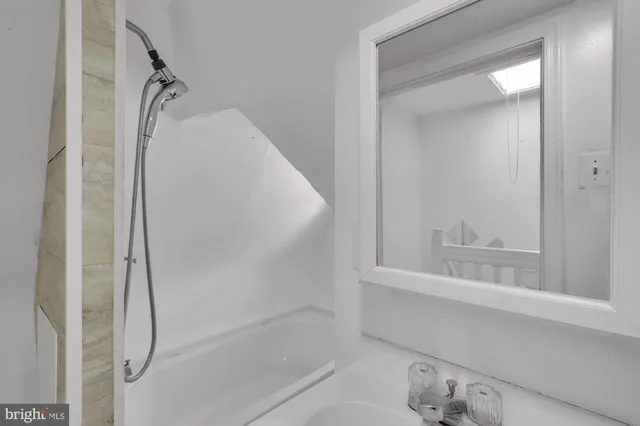 a bathroom with a glass shower door and a sink