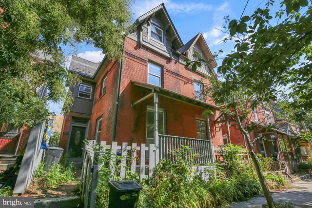a yellow building with trees in front of it