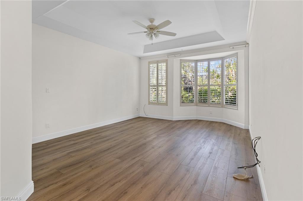 137 Colonade Circle, Unit 601 Naples, FL 34103 - Photo 12 of 28 an empty room with wooden floor and windows