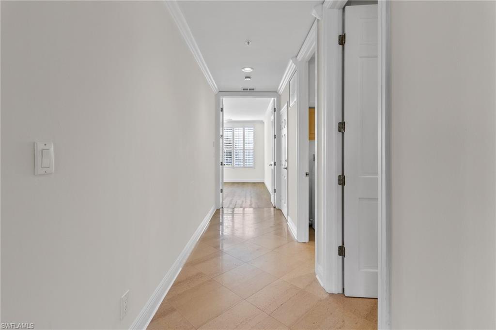 137 Colonade Circle, Unit 601 Naples, FL 34103 - Photo 16 of 28 a view of a hallway with wooden floor and closet