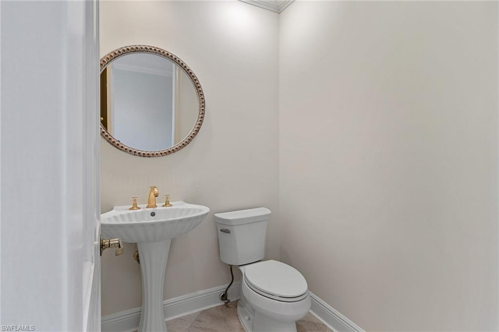 137 Colonade Circle, Unit 601 Naples, FL 34103 - Photo 17 of 28 a bathroom with a toilet sink and mirror