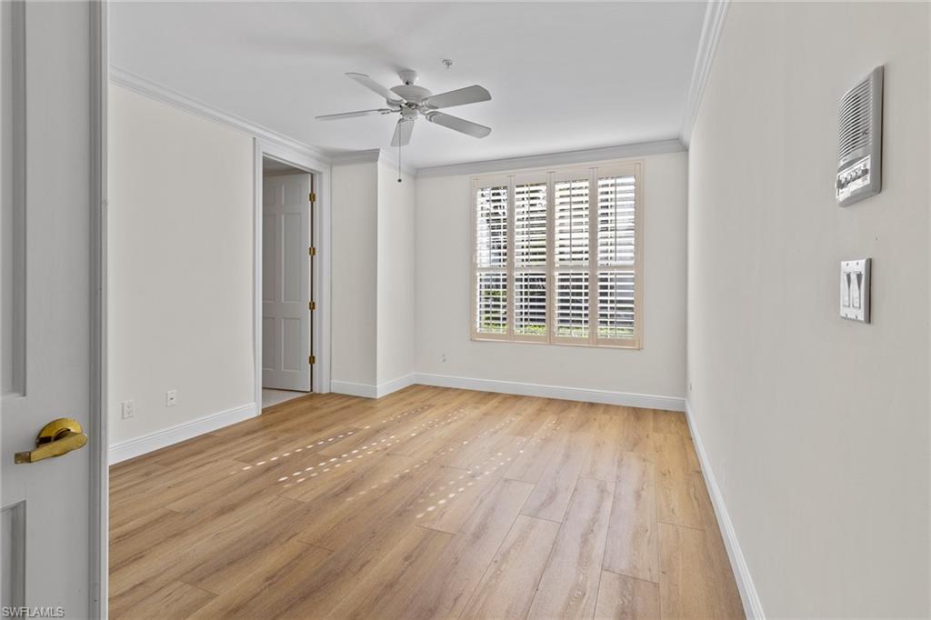 137 Colonade Circle, Unit 601 Naples, FL 34103 - Photo 19 of 28 a view of an empty room with wooden floor and a window