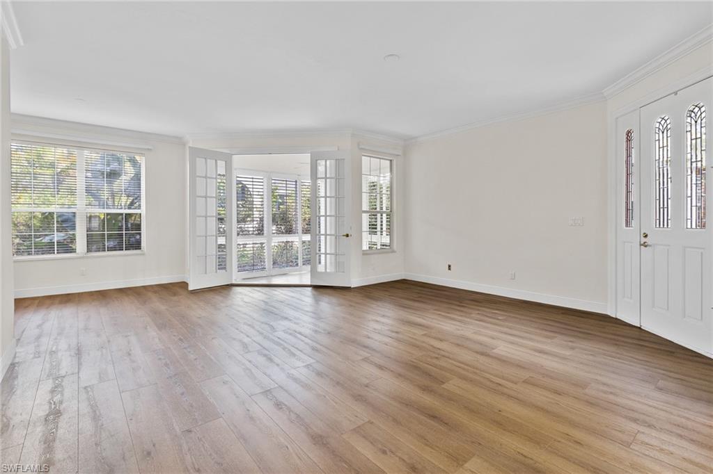 137 Colonade Circle, Unit 601 Naples, FL 34103 - Photo 2 of 28 an empty room with wooden floor and windows