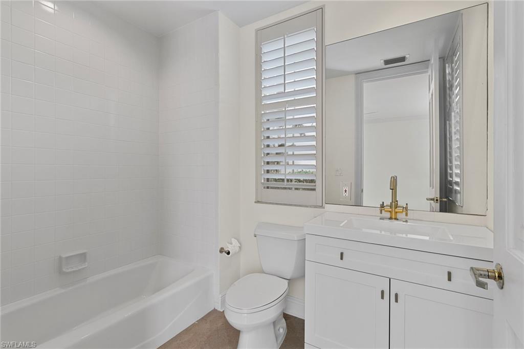 137 Colonade Circle, Unit 601 Naples, FL 34103 - Photo 21 of 28 a bathroom with a granite countertop sink toilet and mirror