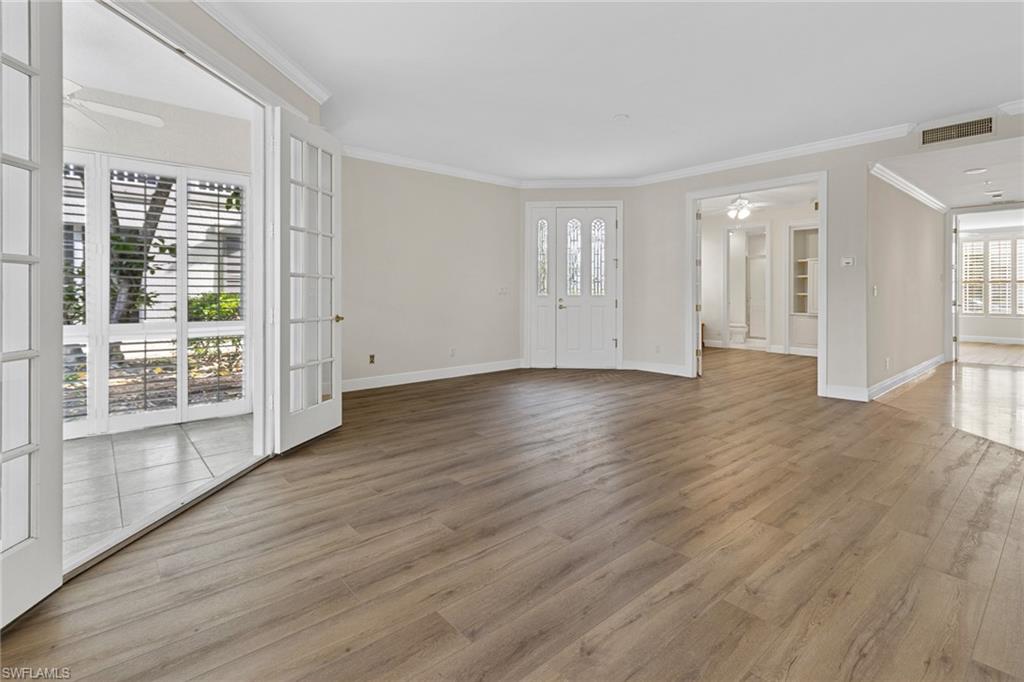 137 Colonade Circle, Unit 601 Naples, FL 34103 - Photo 22 of 28 a view of an empty room with wooden floor and a window