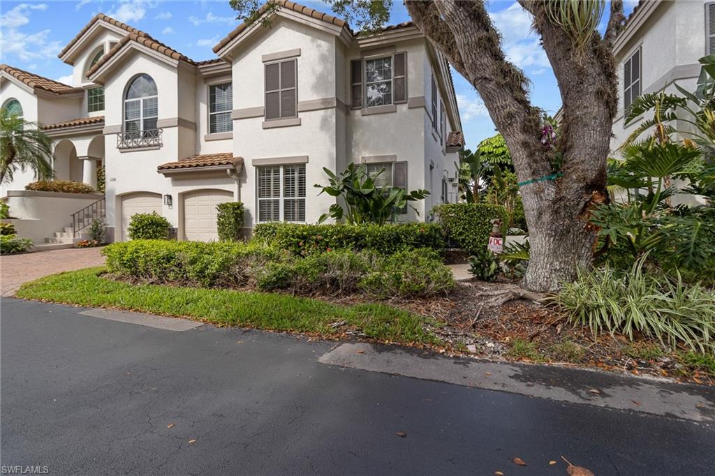137 Colonade Circle, Unit 601 Naples, FL 34103 - Photo 25 of 28 a front view of a house with a yard and garage