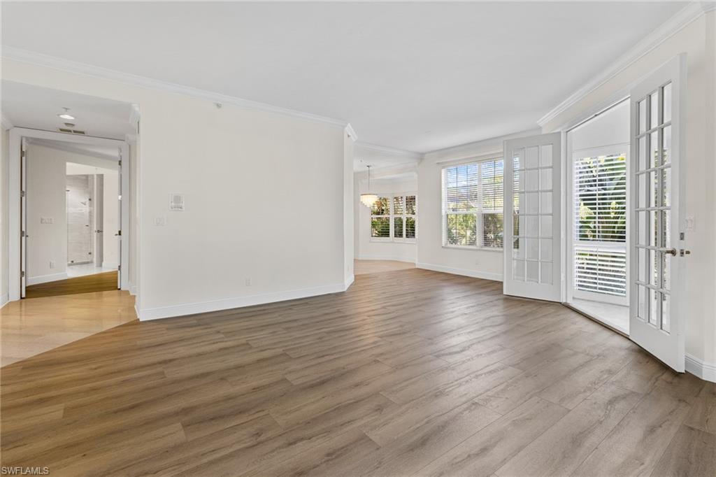 137 Colonade Circle, Unit 601 Naples, FL 34103 - Photo 3 of 28 an empty room with wooden floor and windows