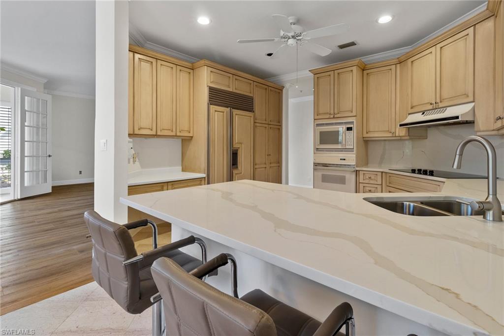 137 Colonade Circle, Unit 601 Naples, FL 34103 - Photo 7 of 28 a kitchen with sink cabinets and wooden floor