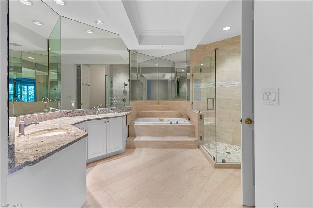 137 Colonade Circle, Unit 601 Naples, FL 34103 - Photo 10 of 28 a bathroom with a granite countertop sink mirror bathtub and shower