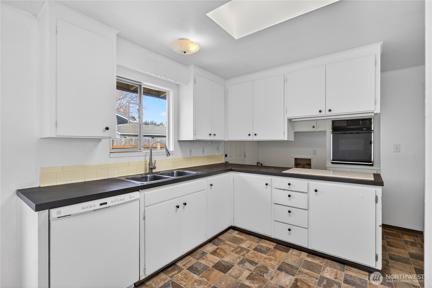 282 Southwest 10th Avenue Oak Harbor, WA 98277 - Photo 8 of 33 a kitchen with granite countertop white cabinets and white appliances