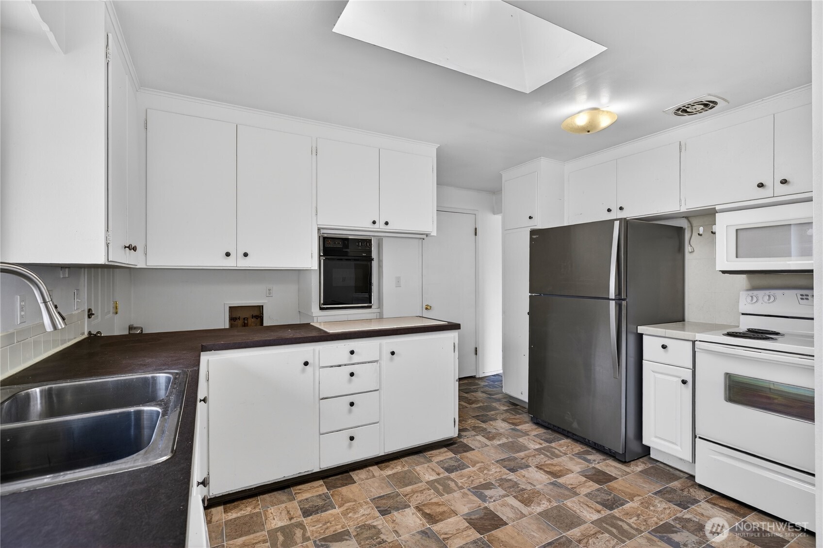 282 Southwest 10th Avenue Oak Harbor, WA 98277 - Photo 10 of 33 a kitchen with stainless steel appliances a refrigerator sink and cabinets
