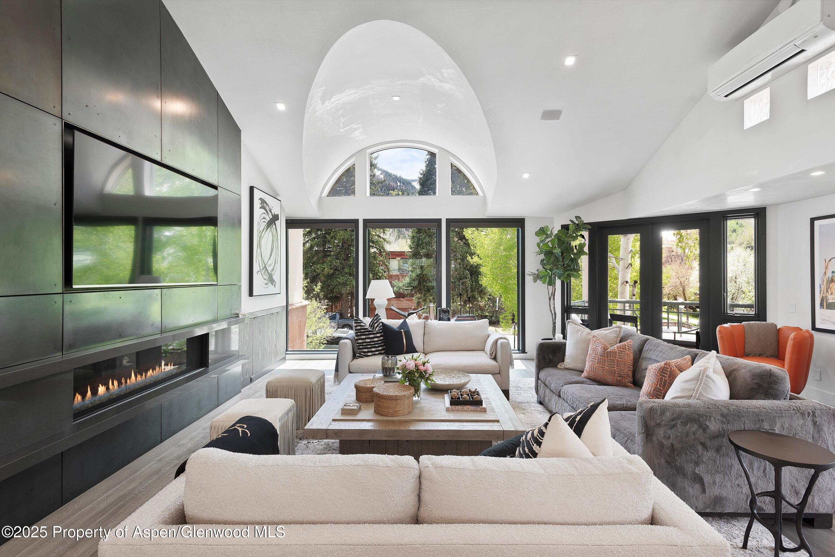 a living room with furniture a flat screen tv and a large window