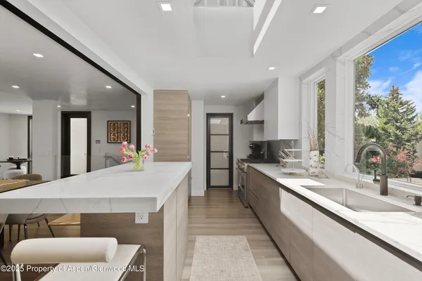 a large kitchen with kitchen island a sink stainless steel appliances and furniture