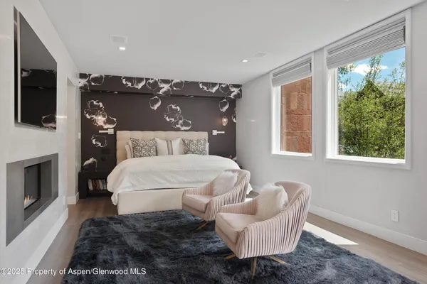 a bedroom with a large bed and a fireplace