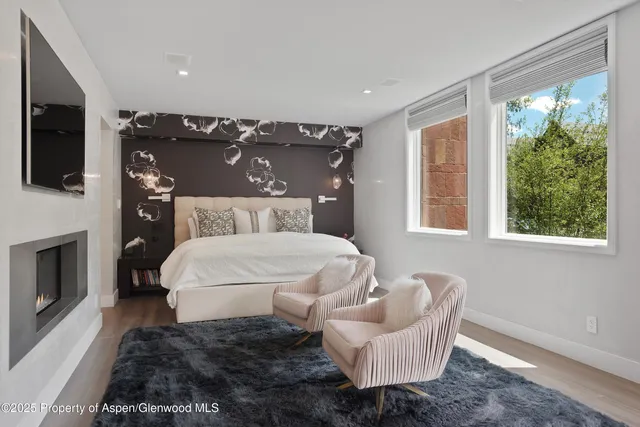 a bedroom with a large bed and a fireplace