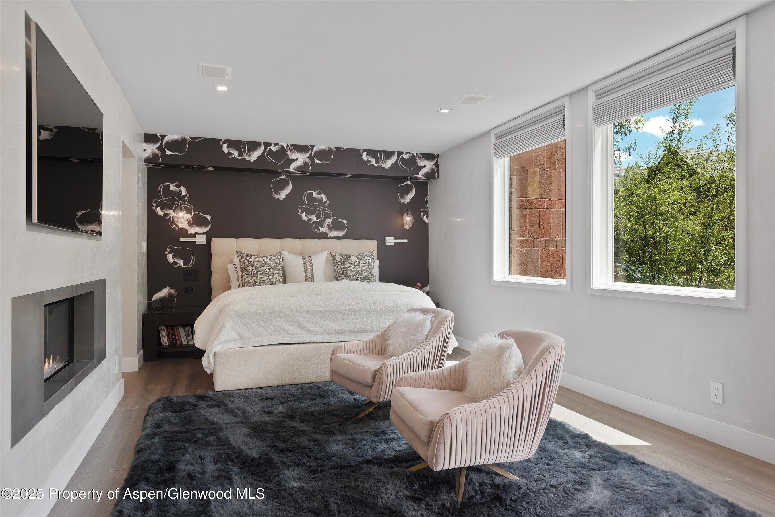 120 South Spring Street, Unit 1 Aspen, CO 81611 - Photo 15 of 37 a bedroom with a large bed and a fireplace