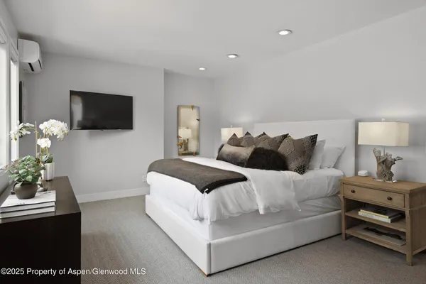 a bedroom with a bed and a flat screen tv