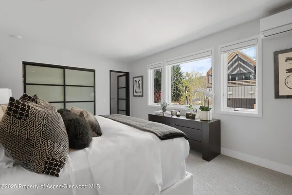 a bedroom with a bed and a large window