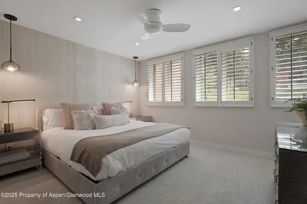 a bedroom with a large bed and a chandelier