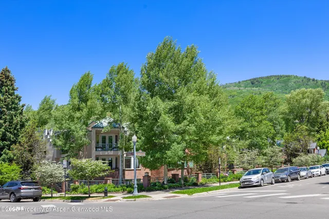 a city street with a building and trees in the background