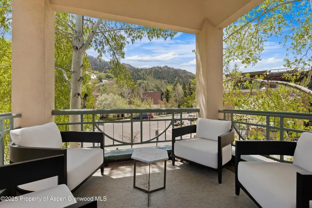 a balcony with couple of chairs and a couch