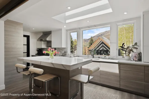 a kitchen with a sink and chairs